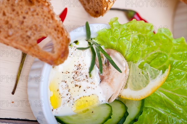 Fresh organic garlic cheese dip salad on a rustic table with bread