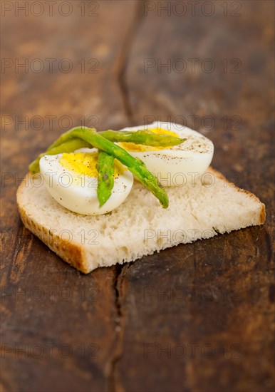 Boiled fresh green asparagus and eggs with extra virgin olive oil with rustic bread