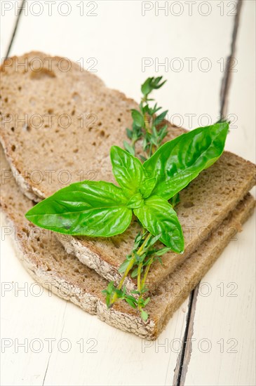 Rustic Italian bread basil and thyme simple snack on white wood table