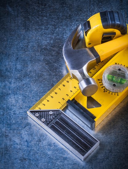 Measuring instruments and claw hammer on a scratched metallic background Design concept