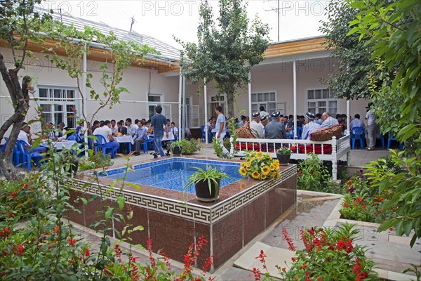 Family and friends gathered at wedding party at married couple's home in Samarkand