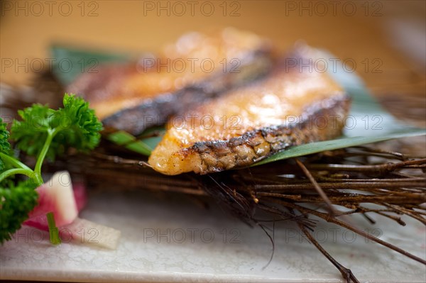 Japanese style teppanyaki roasted cod fish on palm leaf