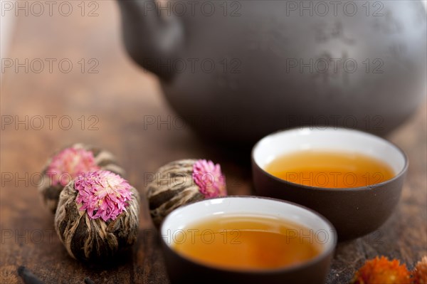 Chinese style herbal floral tea over wood table with raw ingredients