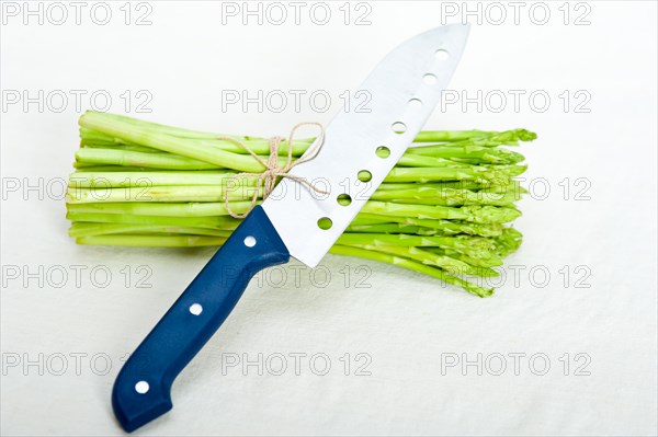 Fresh asparagus from the garden over white background with kitchen knife