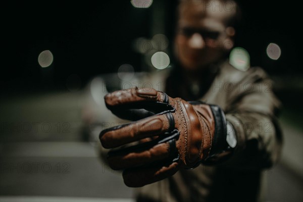 A motorcyclist shows his brown leather touring glove to the camera