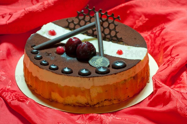 Chocolate birthday cake over red fabric background