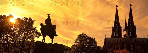 Equestrian statue of Kaiser Wilhelm II backlit with the silhouette of the cathedral
