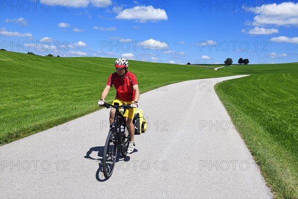 Cyclist on a picture-book country road near Berg