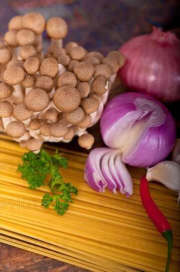 Italian pasta and mushroom sauce raw ingredients over rustic old wood