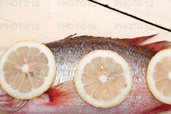 Fresh whole raw fish on a wooden table ready to cook