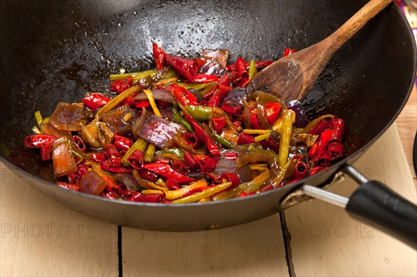 Fried chili pepper and vegetable on a iron wok pan