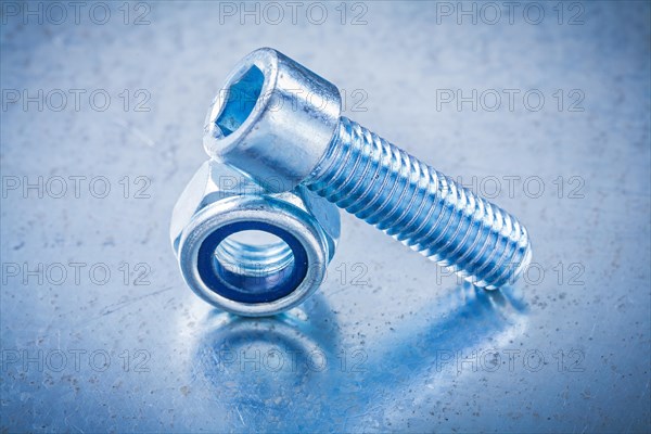 Threaded nut and bolt on metallic background Design concept