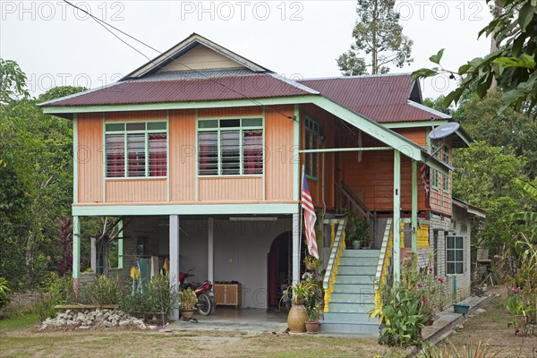 Modern Malaysian wooden house on pillars in the countryside near Taiping