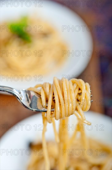 Italian pasta and mushroom sauce over rustic old wood