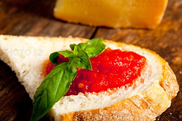 Italian fresh tomato and basil bruschetta with pecorino cheese over old wood