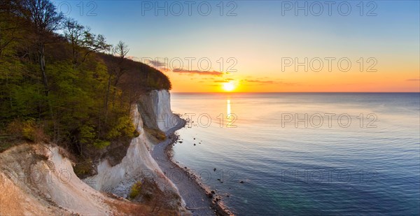 Eroded white chalk cliffs and pebble beach at sunrise in Jasmund National Park on Rugen Island in the Baltic Sea