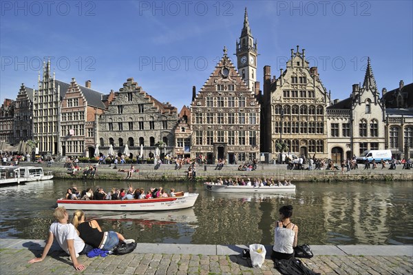 Tourists on quay along the river Lys with view over the Graslei