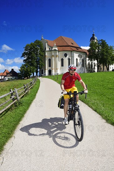 Cyclist with touring bike in front of the Wieskirche