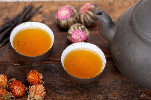 Chinese style herbal floral tea over wood table with raw ingredients