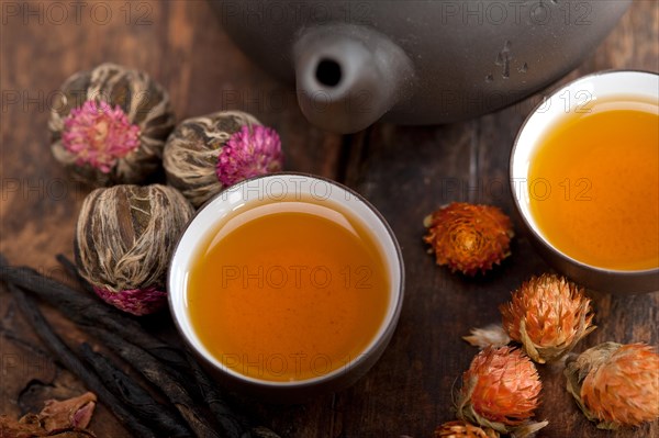 Chinese style herbal floral tea over wood table with raw ingredients