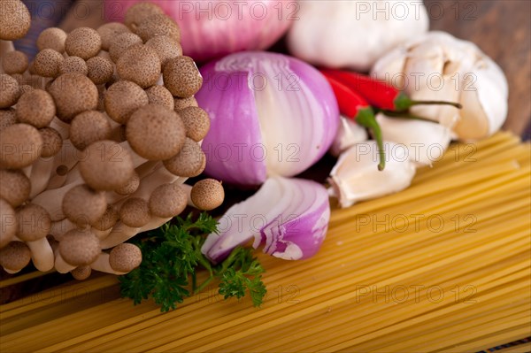 Italian pasta and mushroom sauce raw ingredients over rustic old wood