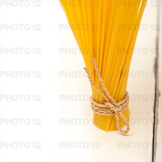 Italian pasta spaghetti tied with a rope on a rustic table