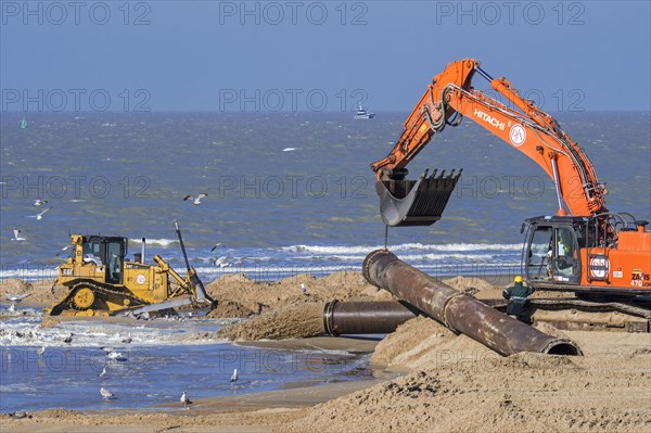 Bulldozer and hydraulic excavator installing pipeline during sand replenishment