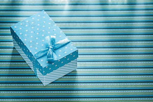 Blue present box on stripy table cloth celebrations concept