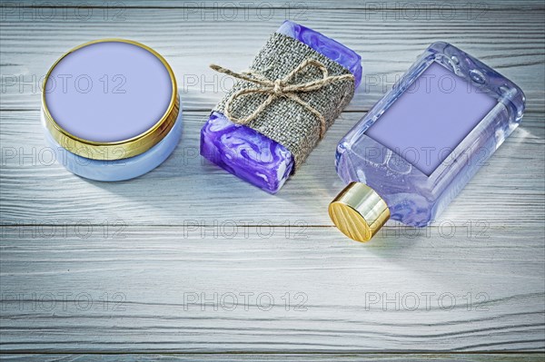 Composition of lavender handmade soap shower gel and body lotion on wooden board spa concept