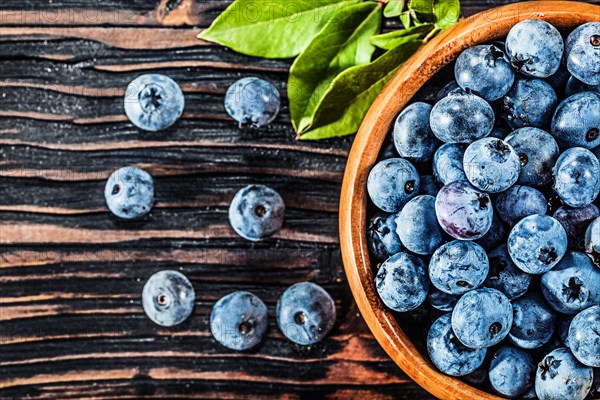 Juicy blueberries in wooden bowl