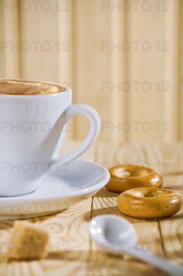 Composition of white coffee cup with spoon and bread gate