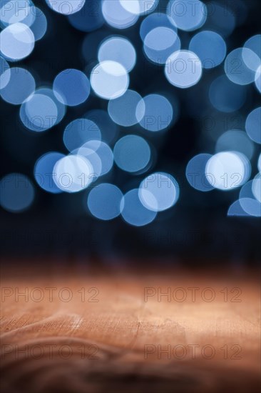 Blank wooden deck table with lights bokeh background ready for your product display mounting