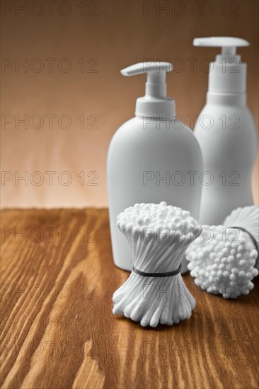 Cotton buds and bottles on a wooden board