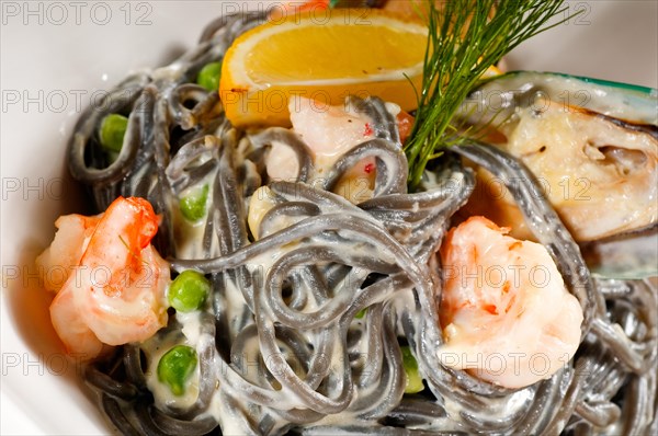 Fresh seafood black squid ink coulored spaghetti pasta tipycal italian food