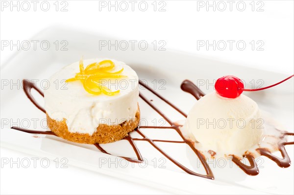 Very elegant lemon mousse dessert served whith lemon peel on top and vanilla ice cream on side