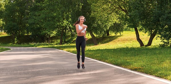 Fitness girl in sportswear runs through the evening sunny park. Healthy lifestyle. Mixed media