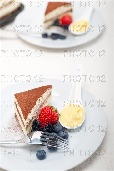 Classic Italian tiramisu dessert with berries and custartd pastry cream on side