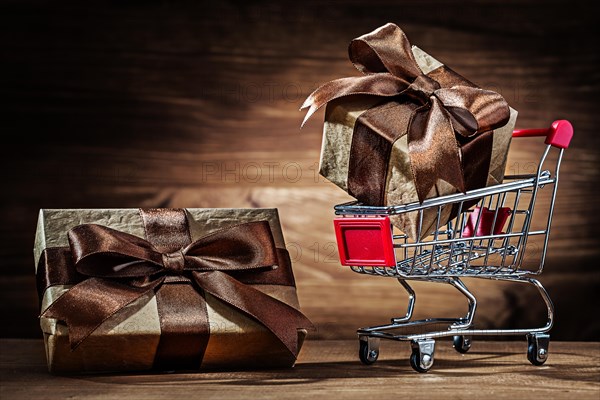 Brown giftboxes and shopping car on vintage wood