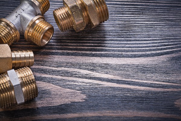 Composition of brass connectors on wooden background plumbing concept