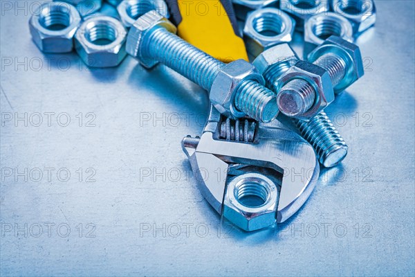 Adjustable key threaded bolt details and screw nuts on metallic background construction concept