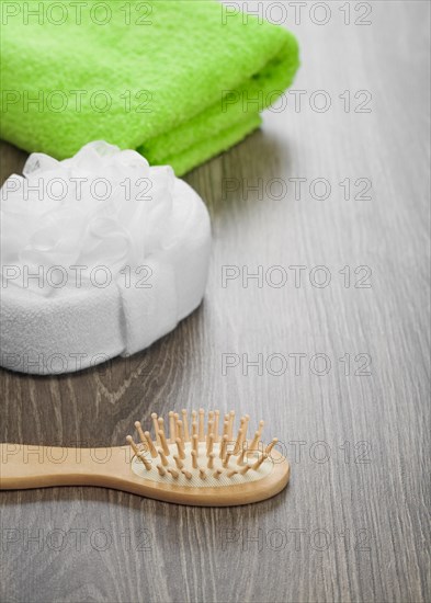 Hairbrush and bath sponge with green towel