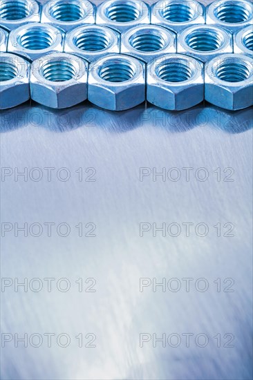 Copyspace image of metal screw nuts on a metallic background Design concept