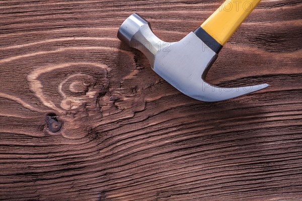 Metal claw hammer on brown vintage wooden board construction concept