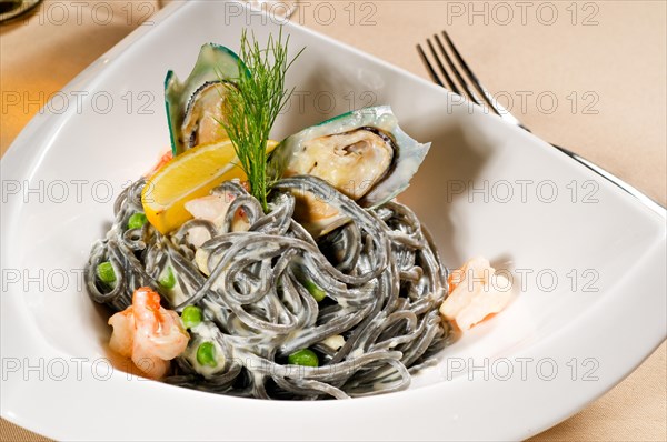 Fresh seafood black squid ink coulored spaghetti pasta tipycal italian food