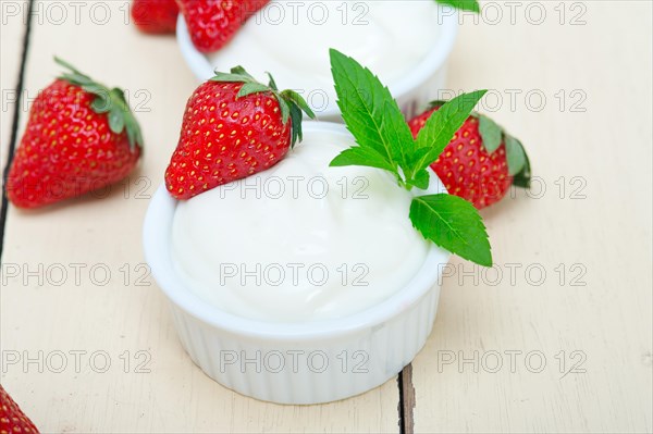 Organic Greek yogurt and strawberry over white rustic wood table