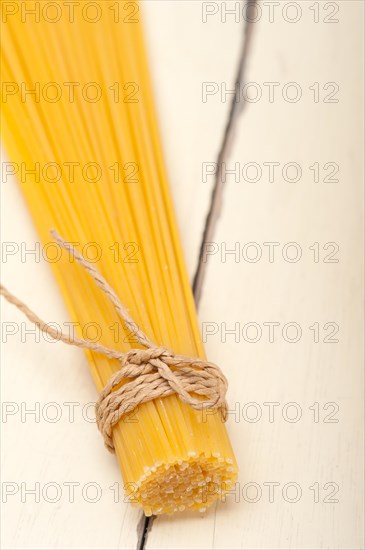 Italian pasta spaghetti tied with a rope on a rustic table