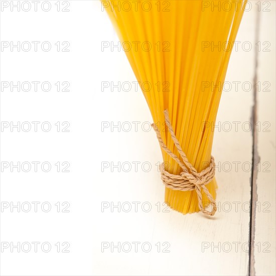 Italian pasta spaghetti tied with a rope on a rustic table