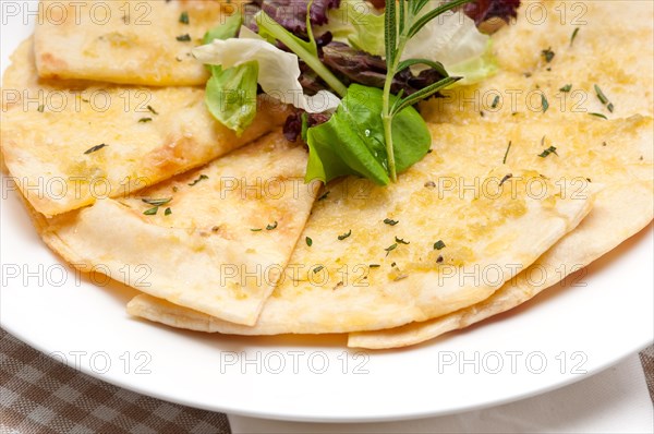 Fresh healthy garlic pita bread pizza with salad on top