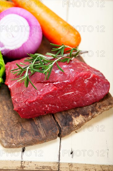 Fresh raw beef cut ready to cook with vegetables and herbs