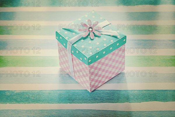 Wrapped present box on blue striped fabric holidays concept